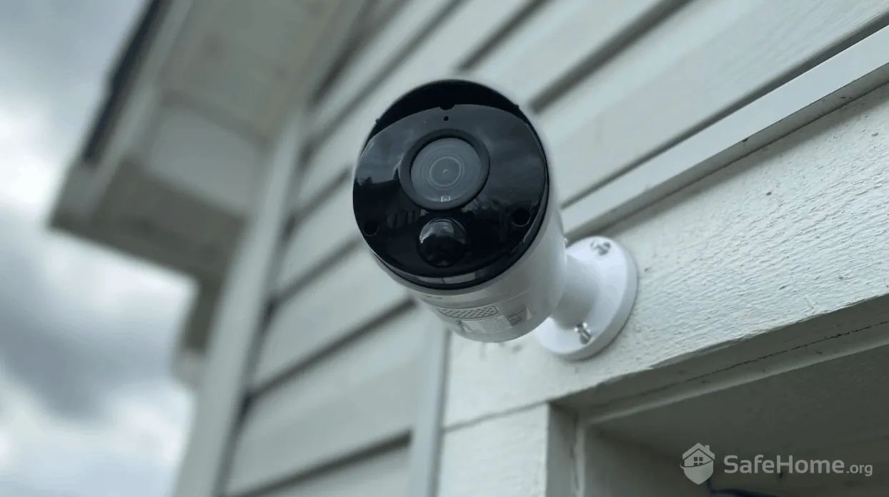 A view from inside a home looking toward a neighbor's outdoor security camera.